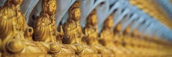 The wall in the temple is filled with buddhas. Religion Buddhism concept. Texture, background Buddhism. BANNER long format