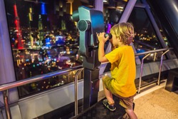 Little boy looks at Kuala lumpur cityscape. Panoramic view of Kuala Lumpur city skyline evening at sunset skyscrapers building in Malaysia. Traveling with kids concept