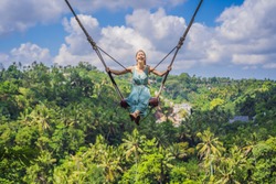 Young woman swinging in the jungle rainforest of Bali island, Indonesia. Swing in the tropics. Swings - trend of Bali