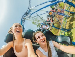 Two happy girls having fun on rollercoaster