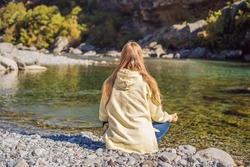 Montenegro. Woman tourist meditates on the background of Clean clear turquoise water of river Moraca in green moraca canyon nature landscape. Travel around Montenegro concept
