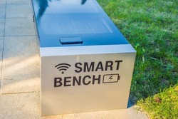 New smart bench in local public park used for charging mobile phones while providing wireless network