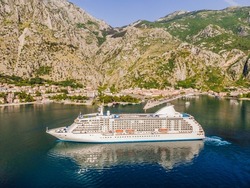 Luxury passenger liner in the bay of Kotor with travel returning after the Covid 19 pandemic Portrait of a disgruntled girl sitting at a cafe table