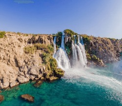 Lower Duden Falls drop off a rocky cliff falling from about 40 m into the Mediterranean Sea in amazing water clouds. Tourism and travel destination photo in Antalya, Turkey. Turkiye.