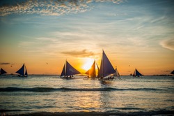 Sailboats with blue sails at sunset, Boracay Island