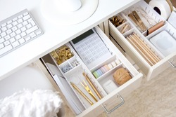 Female workplace. White work table. The stylish gold stationery is arranged very neatly in the drawers of the desk. Japanese storage method.