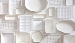 Flat lay of Marie Kondo's white storage boxes, containers and baskets with different sizes and shapes for tidying up wardrobe. KonMari method organizer boxes set. Closet organizing concept.