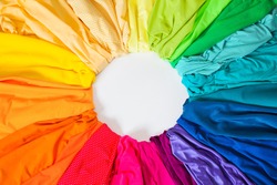 Bright colored fabric flowers laid out on a circle. Material for sewing. Fabric of all colors of the rainbow.