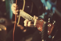 A guy playing an acoustic guitar. Fragment. Focus on the hand