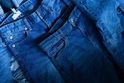 Stack of various shades blue jeans. Pile Blue denim jeans texture banner. Canvas denim fashion texture