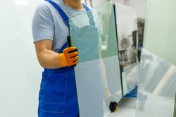 The glazier carries the glass in the glass factory 