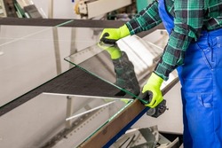 The glazier removes the cut glass from the specialized table in the glass factory, Cutting glass panels 