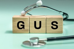 wooden blocks with the words GUS, urogenital system, medical stethoscope, health concept, regular examinations
