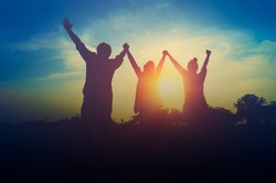 Silhouette of happiness teamwork hold hands up as a business successful, achieve business goal