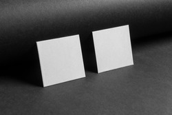 Mock-up of the two square business cards are on a black paper