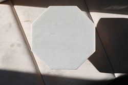 Close-up mockup in beige color. An octagonal figure made of concrete on a beige sofa.