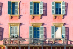 Nice, France, pink facade, with typical windows and shutters
