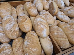 Regular bread loafs in bakery in bakery or grocery store. Freshly baked in shopping display, close-up
