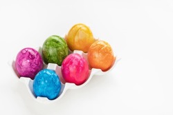 Colorful six Easter eggs in porcelain storage organizer box on white background. Easter celebration concept. Close up, copy space