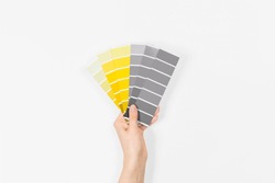 Color swatches with colors of the year 2021 in the hand - Illuminating and Ultimate Grey. Color trend palette. Top view, flat lay. 