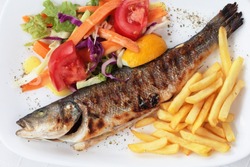 Grilled fish, trout fish with potato, vegetables and lemon, top view
