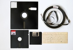 The old 8-inch floppy disk, magnetic tape for an old computer, punched card, a comparison with the flash drive