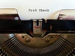 Fact Check, heading title typewritten in black ink on white paper on vintage retro old fashioned obsolete typewriter machine
