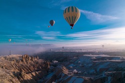 Hot air ballons flying over Cappadocia National Park Göreme Turkey, fogyy air