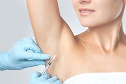The doctor makes intramuscular injections of botulinum toxin in the underarm area against hyperhidrosis. Cosmetology skin care