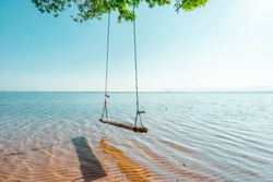 Swings under the shade of trees and tranquil seaside beaches