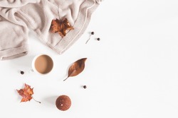 Autumn composition. Cup of coffee, women fashion csweater, autumn leaves on white background. Flat lay, top view, copy space