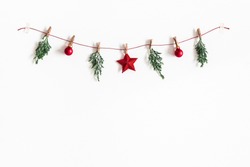 Christmas composition. Garland made of red balls and fir tree branches on white background. Christmas, winter, new year concept. Flat lay, top view, copy space