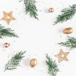 Christmas composition. Christmas frame made of conifer branches, balls, golden decorations on white background. Flat lay, top view, copy space, square.