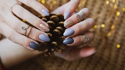 Woman's hands with colorful pattern on the nails. 2021 colors trend. Top view. Place for text. Cozy winter design.