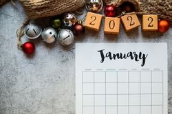 Start of the 2022 year . Date planning, appointment, deadline, or holiday concept on the wooden table next to the black clean calendar on the month of January 2022