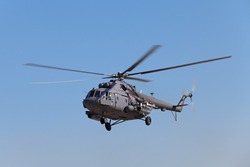 The military helicopter against the blue sky