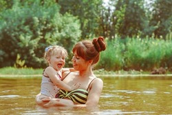 mother and daughter bathe in the river