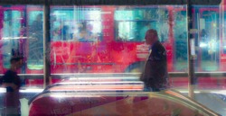 Blurry people rushing alone through city blurs, lights and vibrant colors, on the sidewalk, subway entrance and the traffic behind them