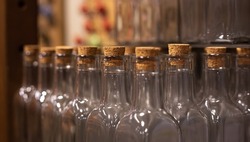 Close-up, empty glass bottles with corks on a blurred background.