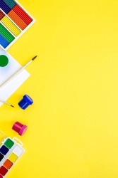 Colourful school supplies on a yellow background, back to school concept.