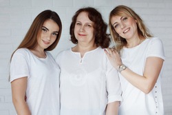 Family, grandmother, grandson, dad, mother in blue jeans and white T-shirts in casual style in a photo studio