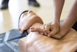 CPR training medical procedure - Demonstrating chest compressions on CPR doll in the class 