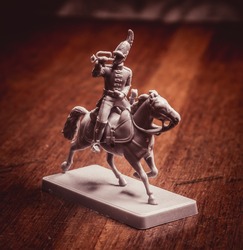 Figure of a soldier on a horse on a wooden background. Photo toned.