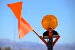 road closure construction barricade with bright orange caution flag