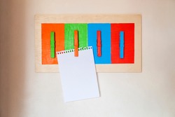 

Colorful handmade scrapbook with blank sheet for scrapbook notes, reminder, shopping list and notice. Mural made with wood and clothespin and painted. Diy concept. Reminder concept.