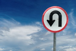 U turn sign on white cloud and blue sky background with clipping path