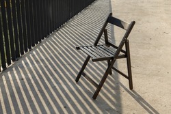 empty chair outdoors harsh shadows copy space