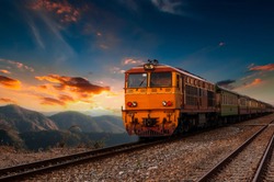 The train is running to the destination station when the sun is going down in the evening in a beautiful natural way in Thailand.