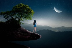 The girl stood alone and looked at the half moon on the cliff alone.