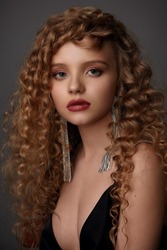 portrait of a beautiful girl with perfect make-up and stylish hairstyle with curled hair
